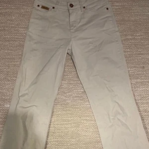 Vira bootcut jeans från Wrangler - Snygga vits byxor från Wrangler med klassisk design. Byxorna är bootcut och är tillverkade i ett bekvämt bomullsmaterial. Perfekta för en stilren look.