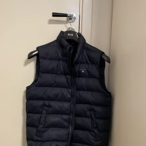 Gant väst  - Nu säljer vi dennna mycket snygga väst, den har en fin marinblå färg och ser vädligt elegant ut. Nypris 1599, vårt pris 449. Storlek Xs, modellen är 174. Den är sparsamt använd och det finns inga tecken på användning. Priset är inte hugget i sten. Vid funderingar är det bara att höra av sig! 🙌