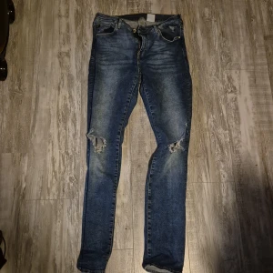 Skinny jeans - Blåa skinny jeans med hål i knäna 