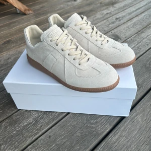 Maison Margiella skor  - Hej, säljer dessa tvär feta Maison margiella skor eftersom dom är för små. Dom är i en beige färg som är väldigt unik. Skriv för frågor.