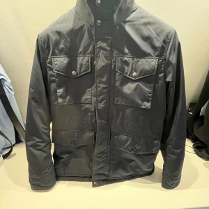 J Lindeberg jacka strl S - Jackan är i väldigt fint skick. Köptes på Åhléns för något år sedan. Perfekt till höst och vinter då den är av lite tjockare material!