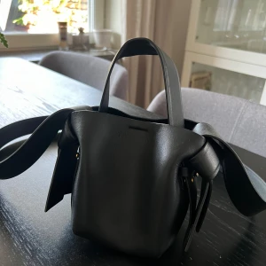 Acne Studios Musubi - Säljer min favorit väska från Acne Studios i modellen Musubi. Det är micro modellen och är den perfekta lilla svarta väskan.  I mycket bra skick och använt varsamt. Medföljer dust bag och kvitto 🌼