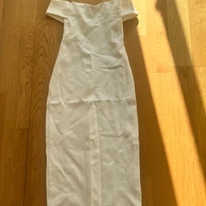 Klänning  - Letar du efter det ultimata statement-plagget för ditt nästa evenemang? Sök inte längre! Vår ärmlösa, rygglösa festklänning utstrålar elegans och sofistikering. Med sin eleganta design och smickrande silhuett är denna klänning perfekt för att göra en
