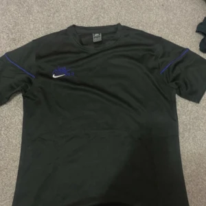 Svart Nike tröja - Jag säljer min svarta Nike tröja med blå linjer vid armen