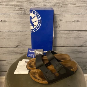 Birkenstock tofflor - Tja! Säljer nu dessa Birkenstock (Storlek 42) som skulle kunna funka för en storlek 43 också, fint skick då dem bara är använda med strumpor på, finns täcken på användning men är i allmänt gott skick, vid frågor är det bara att höra av sig