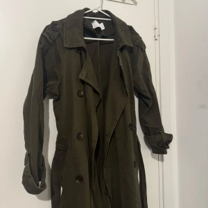 Kappa - Grön lång kappa från Asos i färgen militärgrön. Passar perfekt till hösten. Använd 3-4 gånger, mycket bra skick. Skriv för fler bilder.  