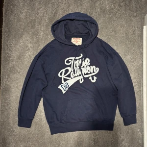 Mörkblå hoodie från True Religion - Säljer en snygg mörkblå hoodie från True Religion ☑️ Bra skick, inga defekter ☑️Märkt som M men passar snarare S/XS☑️. Perfekt för en avslappnad stil och passar bra till både jeans och joggers. 