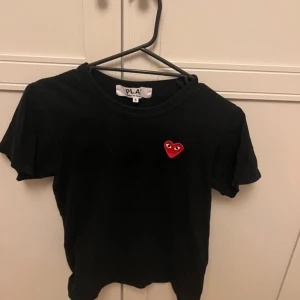 Comme des garcons tshirt - Svart T-shirt med rött hjärta med ögon.  Den är ifrån comme des garcons och är nästan aldrig använd, jättefin kvalitet på tröjan! 