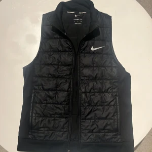 Nike sport väst - Skick 8/10, Nike sport väst svart färgad med reflex loggo fram och reflex bak. Storlek XS bra fickor bra om man ska springa eller sådant nu mot hösten kan även vara tillräckligt varm med typ en hoodie under för promenader och liknande 