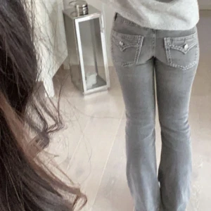 Grå bootcut jeans med detaljer - Snygga grå bootcut jeans med detaljer på bakfickorna. Lågmidjade jeans har använts ett fåtal gånger och är mycket bra i skick! Skulle säga xs-158 i storlek.
