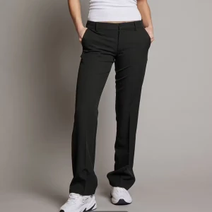 Svarta kostymbyxor - Snygga svarta kostymbyxor med en klassisk bootcut-stil. Perfekta för en stilren look. Byxorna har en lågmidjad passform och är tillverkade i ett bekvämt material.