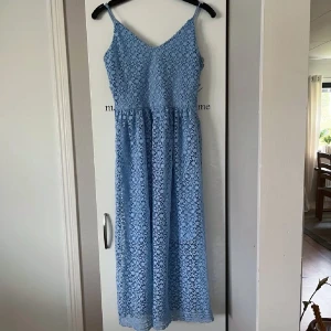 Blå spetsklänning - Superfin balklänning i ljusblått med blommigt spets tyg och underkjol. Smala axelband och v-ringad. På bilden var jag 1,58. Endast använd en gång. Skriv gärna vid önskan av fler bilder eller mått! 🩵