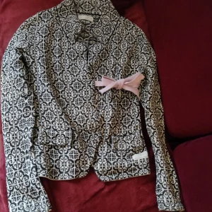 Odd Molly lovely knit kofta  - Säljer en snygg mönstrad kofta från Odd Molly i svart och vit med rosa rosett. Koftan är i nyskick då det är fel storlek för mig. 100% bomull. Strl 1 vilket motsvarar small 
