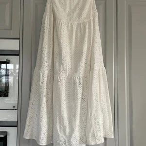 Vit klänning från Kappahl - Säljer en söt vit långkjol från Kappahl med broderade detaljer och volanger. Den är i storlek 170 och jag säljer den för att den är för lång för mig som är 164🤍🌸