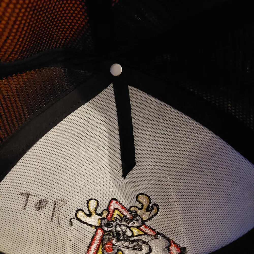 Snygg grå keps med ett roligt Hälge-motiv på framsidan. Kepsen har ett nätmaterial på baksidan för bättre ventilation och justerbar passform. Perfekt för dig som gillar humoristiska accessoarer!. Asusteet.