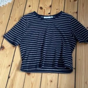 T-shirt från weekday - Säljer denna croppade, randiga t-shirten från weekday. Den är i storlek s och den är knappt använd.