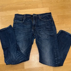 Levis jeans - Säljer ett par klassiska Levis 502 jeans i mörkblå denim. De har en normal passform med dragkedja och knappstängning. 