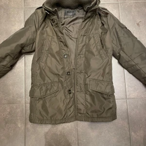 Mörkgrön fieldjacket  - Säljer en olivgrön jacka från Zara med både dragkedja och knappar framtill. Jackan har långa ärmar och flera praktiska fickor. Perfekt för kyligare dagar med sin stilrena design och bekväma passform. Pris kan diskuteras vid enkel affär. Storlek S men passar även M. Är 176 o 70kg o den sitter utmärkt! 