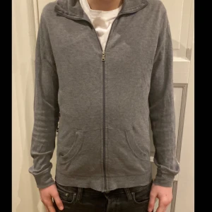 Tezenis full zip - Säljer en grå full zip från Tezenis med dragkedja och två fickor framtill. Tröjan har långa ärmar och en bekväm passform.  Hör av dig vid intresse!