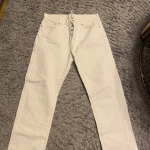  Falkenberg  - Snygga vita jeansbyxor med klassisk femficksdesign och knappgylf. Perfekta för en stilren look, dessa byxor har en rak passform och är tillverkade i ett slitstarkt material. Passar utmärkt för både vardag och mer uppklädda tillfällen.