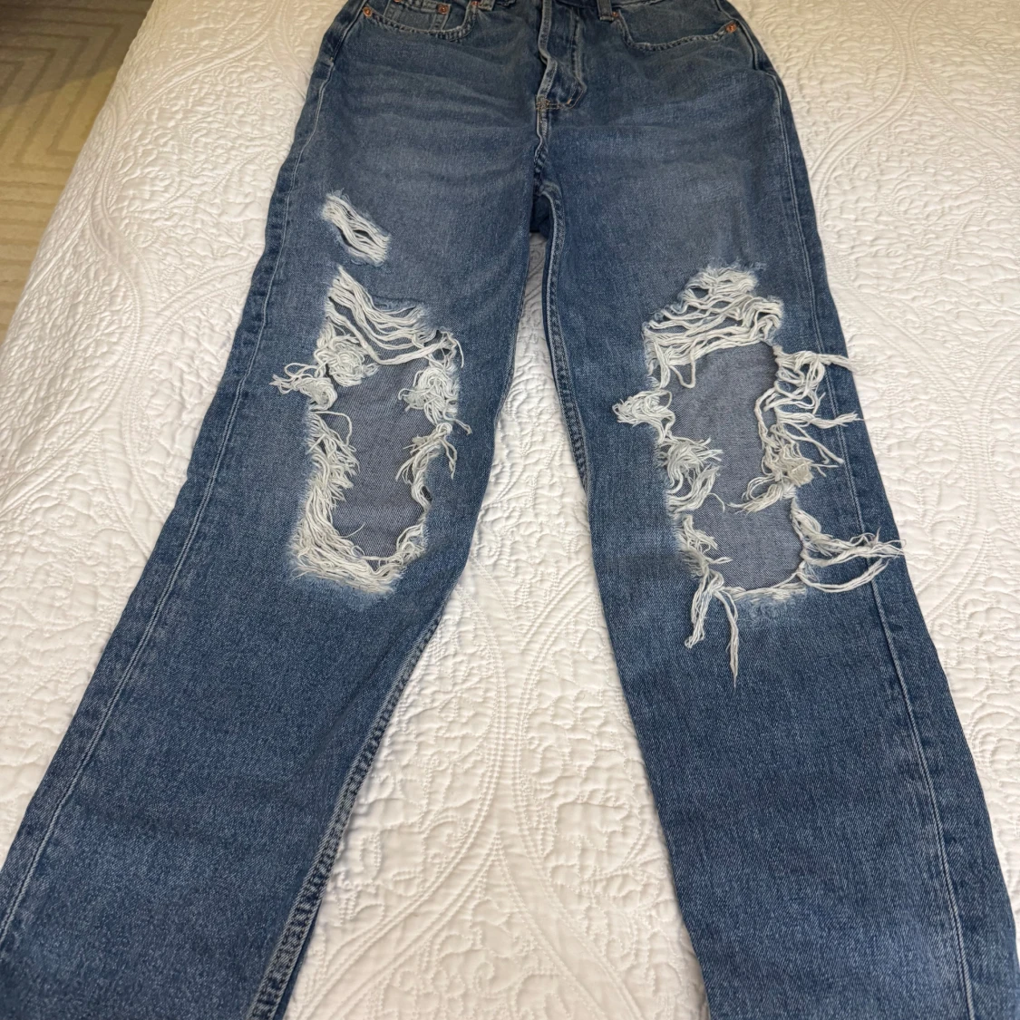 Blå jeans med slitningar