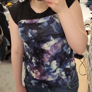  Träningstopp från SOC - Snygg träningstopp från SOC i blå och lila nyanser. Toppen har korta ärmar och en bekväm passform, perfekt för träning. Materialet är lätt och andas bra.