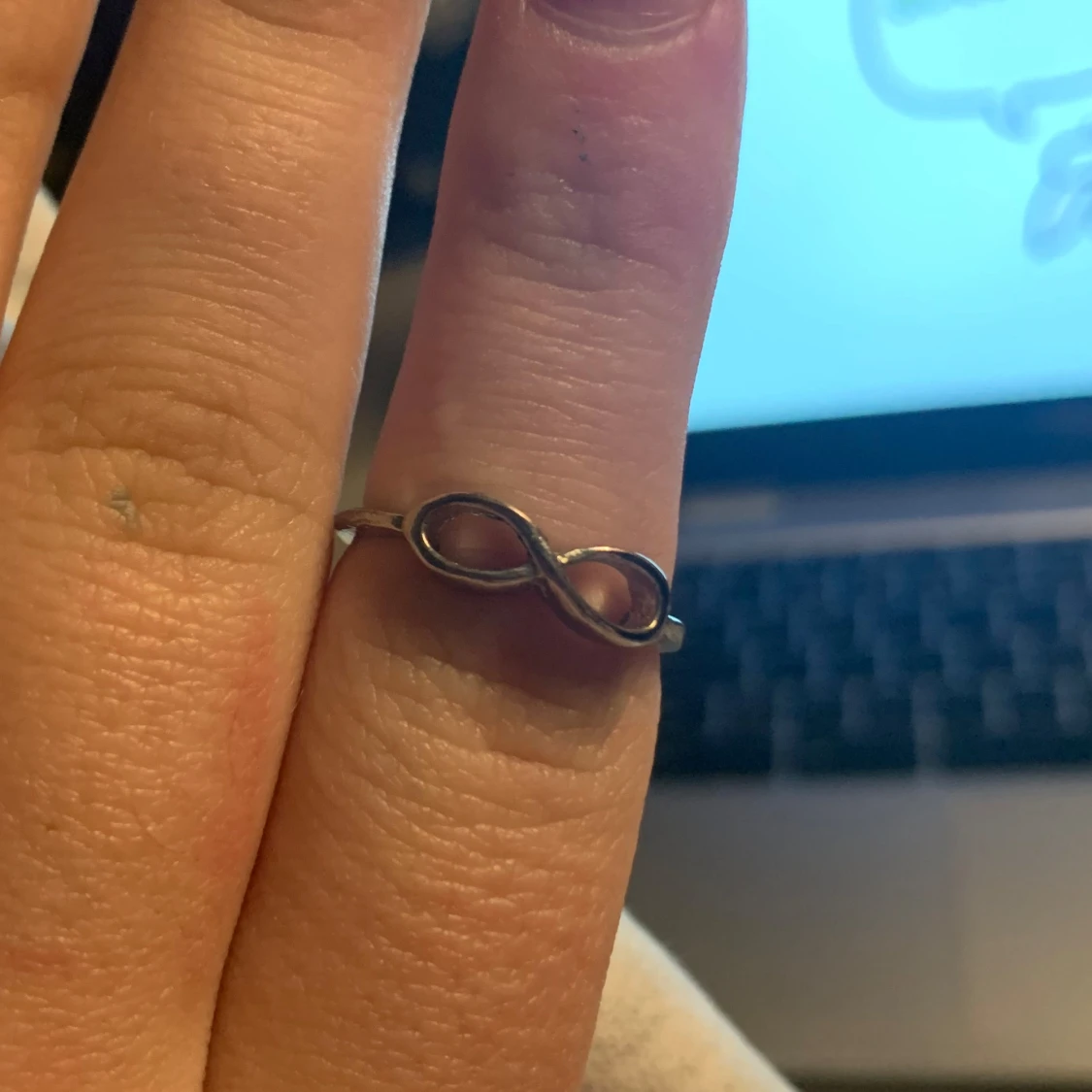 Silverfärgad ring med oändlighetssymbol