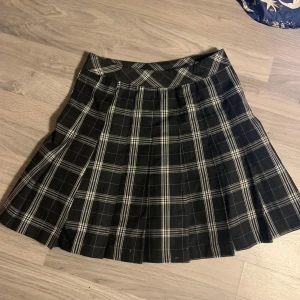 Svart och vit rutig kjol från H&M Divided - Snygg svart och vit rutig kjol från H&M Divided. Kjolen har en dragkedja och knapp för enkel på- och avtagning. Ge gärna prisförslag!😁