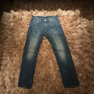 Levis 502 jeans - Snygga Levis 502 jeans i en klassisk blå färg. De har en straight/regular passform och är tillverkade i slitstarkt denim. Perfekta för en avslappnad stil med en ikonisk Levis-lapp på baksidan.