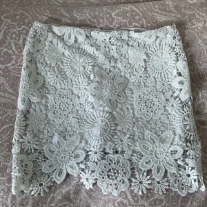 Vit spetskjol från Atmosphere - Säljer en superfin vit spetskjol från Atmosphere. Kjolen har ett vackert blommönster och är fodrad för extra komfort. Perfekt för somriga dagar eller speciella tillfällen. Den har en normal passform och är i storlek 40. 🌸