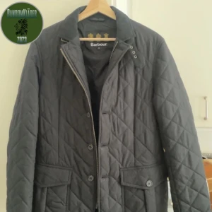 Svart quiltad jacka från Barbour - Snygg svart quiltad jacka från Barbour med klassisk design. Jackan har långa ärmar och stängs med både dragkedja och knappar. Perfekt för kyligare dagar med sin stilrena look. Jätte bra skick på den finns inga hål eller något annat storlek S men passar perfekt på mig som har M. Pris gå att diskutera vid snabb affär 👍🏼🩵❄️