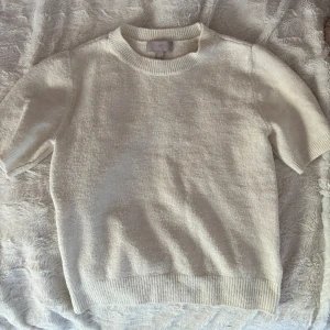 Stickad T-shirt  - Vit/beige stickad T-shirt från hm. Lite halv puffiga ärmar, den är lite nopprig också därav priset🩷🩷