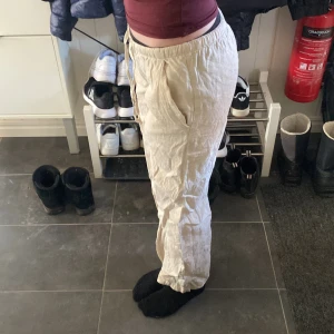Beige linnebyxor - Säljer ett par bekväma beige linnebyxor med elastisk midja och avslappnad passform. Perfekta för en avslappnad stil och sköna att bära under varmare dagar.