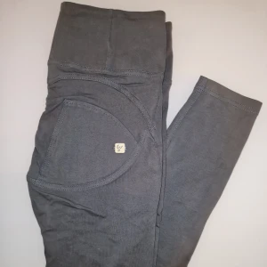 Grå byxor från Freddy Wr Up - Snygga grå byxor från Freddy med hög midja och dragkedja framtill. Byxorna har en tight passform och är tillverkade i ett mjukt och stretchigt material. Garderobsrensning så kika gärna på övriga auktioner. 