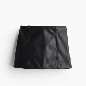 Skinnkjol - Snygg svart mini kjol i skinn med en stilren design. Kjolen har en tight passform och är perfekt för att ge en edgy look. Den är enkel att matcha med olika toppar och accessoarer. Helt ny med lapp! 💕💕passar mig som brukar ha storlek 34!