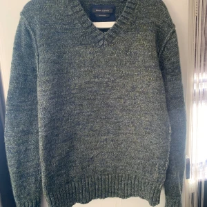 Grön stickad tröja från Marc O'Polo - Säljer en grön stickad tröja från Marc O'Polo i alpackaull. Tröjan har en v-ringad hals och ribbade muddar vid ärmslut och nederkant. Perfekt för kyliga dagar!