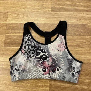 Mönstrad sporttopp från SOC - barn - Snygg sporttopp från SOC med ett unikt mönster i grått, rosa och svart. Toppen har en brottarrygg och är perfekt för träning. Materialet är mjukt och stretchigt för bästa komfort.