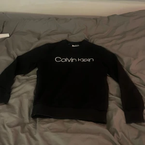Svart tröja från Calvin Klein - Säljen en sweatshirt av märket Calvin Klein i storlek S. Tröjan är knappt använd och är därför i mycket bra skick. Hör av dig vid frågor!