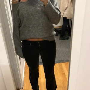 Svarta jeans med bootcut - Snygga svarta jeans med bootcut-stil och låg midja. Perfekta för en avslappnad look. De har klassiska fem fickor och knappar framtill. Märke Only 