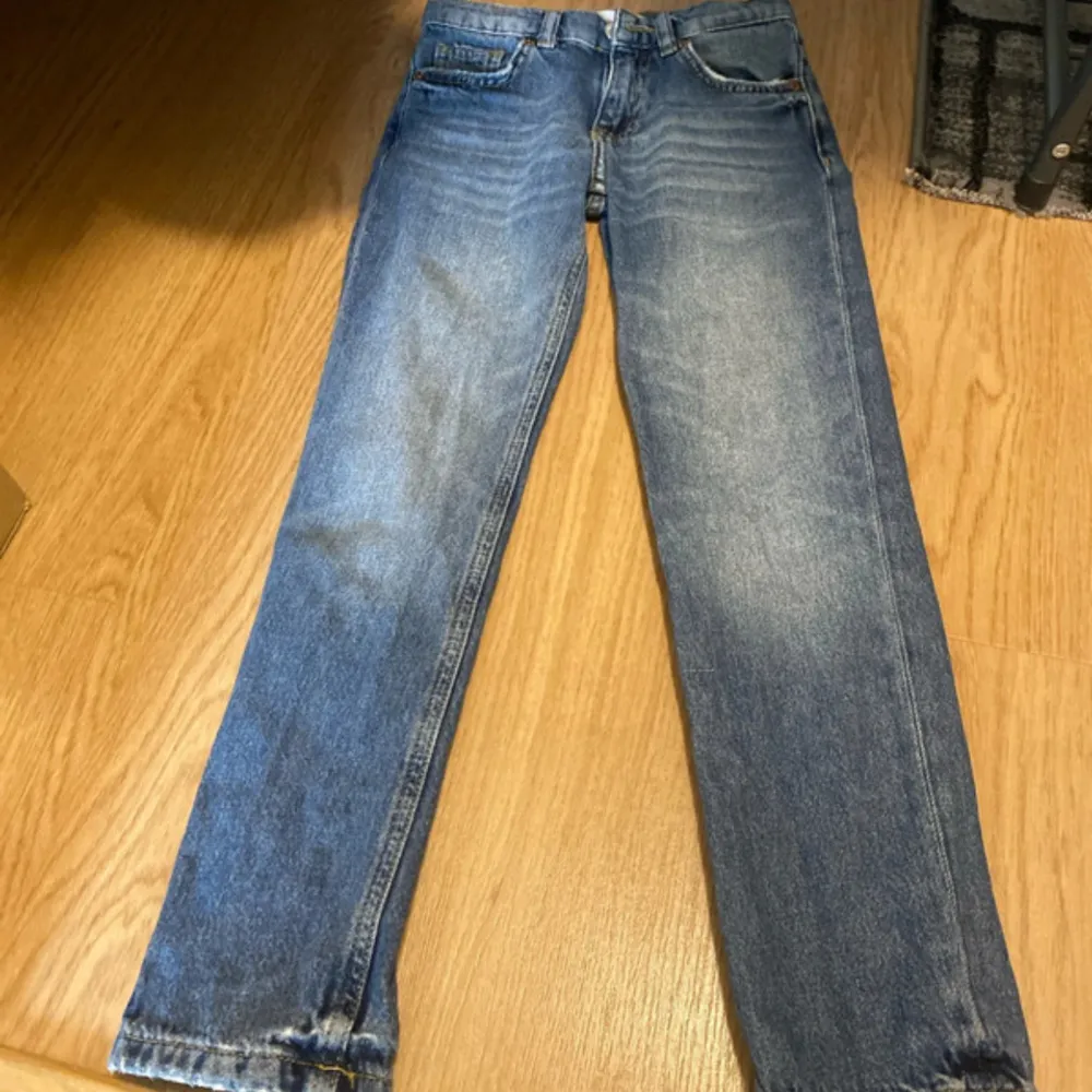 Säljer ett par klassiska blå jeans från Zara. De har en straight passform och är tillverkade i denim med en snygg tvätt. Perfekta för en avslappnad stil.. Farkut & Housut.
