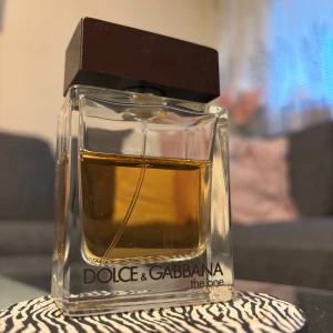 Dolce & Gabbana The One - Säljer en elegant parfym från Dolce & Gabbana, The One. Flaskan är stilren och fyrkantig med en mörkbrun kork. Doften är varm och sensuell, perfekt för den som vill sticka ut. Flaskan rymmer 50 ml och är en klassiker i parfymvärlden.
