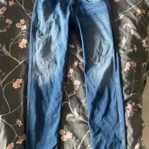 Replay anbass - Snygga blå jeans från Replay i modellen Anbass. De har en slim fit passform och klassisk femficksdesign. Perfekta för en stilren look. Jeansen har ett par fina slitningar som gör att de ser snyggare ut. Skicket är i 8/10 då de är använda ungefär 6 gånger. Jag säljer dessa eftersom jag har ett par likadana och de kommer inte till användning
