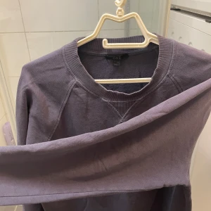 Tjocktröja COS - Säljer en stilren lila tröja från COS i storlek S. Tröjan har en rund halsringning och långa ärmar, perfekt för en avslappnad look. Passar bra till både jeans och kjol. Hör av dig vid intresse!