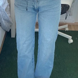 Ljusblå jeans med mid midja - Snygga ljusblå jeans med mid midja och klassisk femficksdesign. De har en straight passform som ger en avslappnad look. Perfekta för en casual stil.