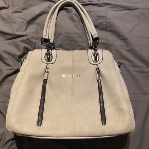 Michael Kors Väska - Superfin grå/beige väska ifrån Michael Kors 💕 Jättefint skick, lite smutsig därav priset. Följer med olika remmar ifall man ej vill ha dem som sitter på nu. Jättefin och fräsch insida, med flera olika fickor. Lätt att organisera i, perfekt skolväska kanske? 💗