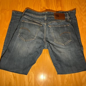 Blå jeans från G-Star RAW - Storlek: W28/L30 Snygga blå jeans från G-Star RAW, modell 3301 Slim. De har en klassisk femficksdesign och en slim passform som ger en modern och stilren look. Jeansen har inga defekter och är 9,5/10 i skick! Nypris är 1199kr Mitt pris är 299kr!! Bara höra av dig vid funderingar eller prisförslag! 