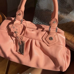 Marc Jacobs väska  - Snygg rosa Marc Jacobs väska. Väskan har en praktisk storlek och är lätt att bära med sig. Super fin till outfits och väldigt trendig, ganska unik färg som det inte säljs många av. 💗intressekoll för bästa bud. 