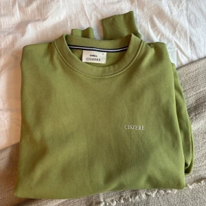 Grön sweatshirt från Ciszere - Snygg grön sweatshirt från Ciszere med rund halsringning och broderad logga på bröstet. Perfekt för en avslappnad stil.