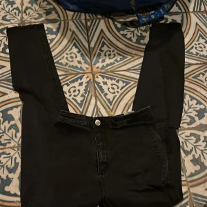 Svart/grå skinny jeans med hål vid knäna min syrra som har haft dom är 170  - Snygga svarta jeans med slitningar på knäna. Perfekta för en avslappnad och trendig look. De har en klassisk femficksdesign och knappgylf.