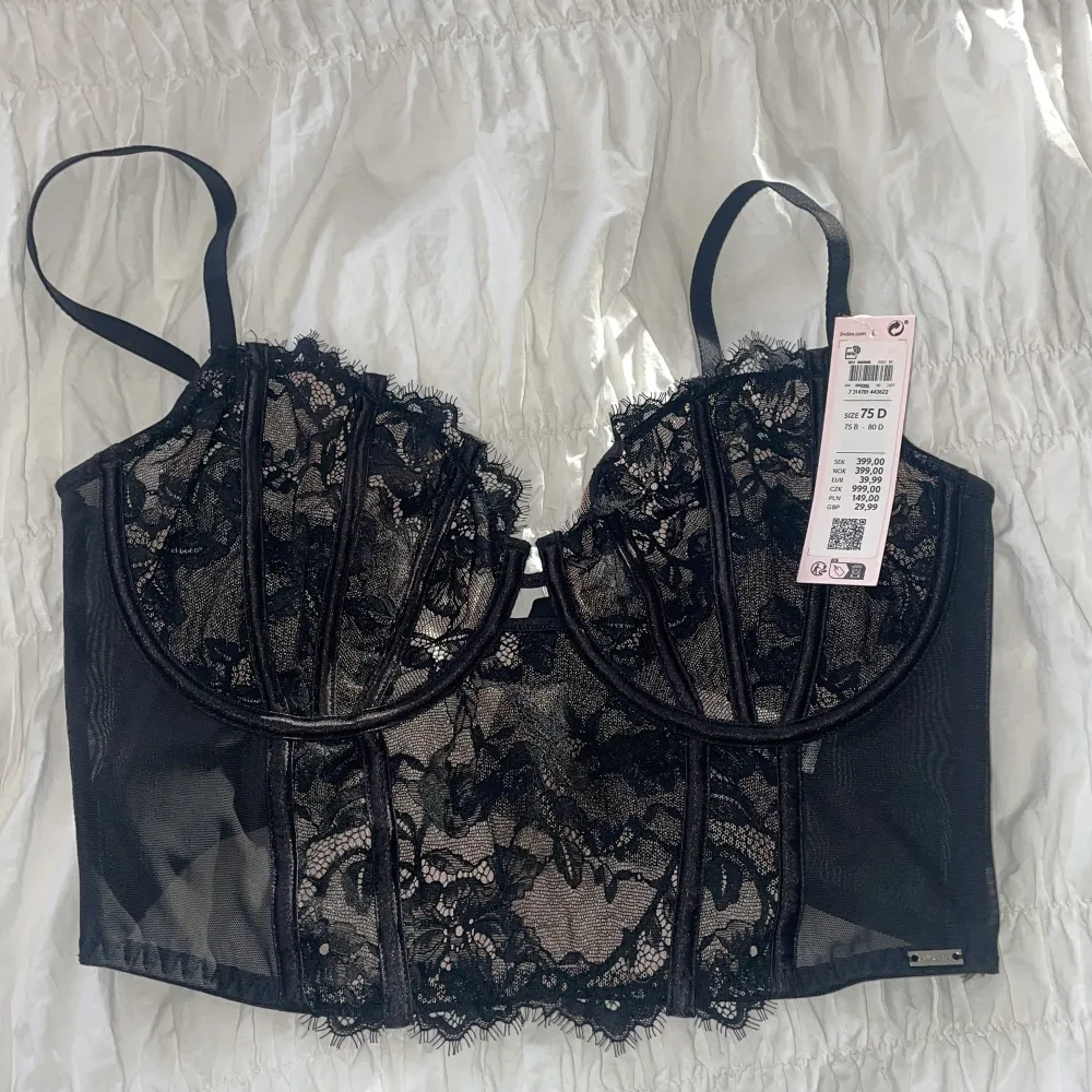 Svart korsett med spetsdetaljer. Helt ny och oanvänd. Säljer då den tyvär inte passade och är försent att lämna tillbaka. Nypris: 399kr💕. Yläosat.
